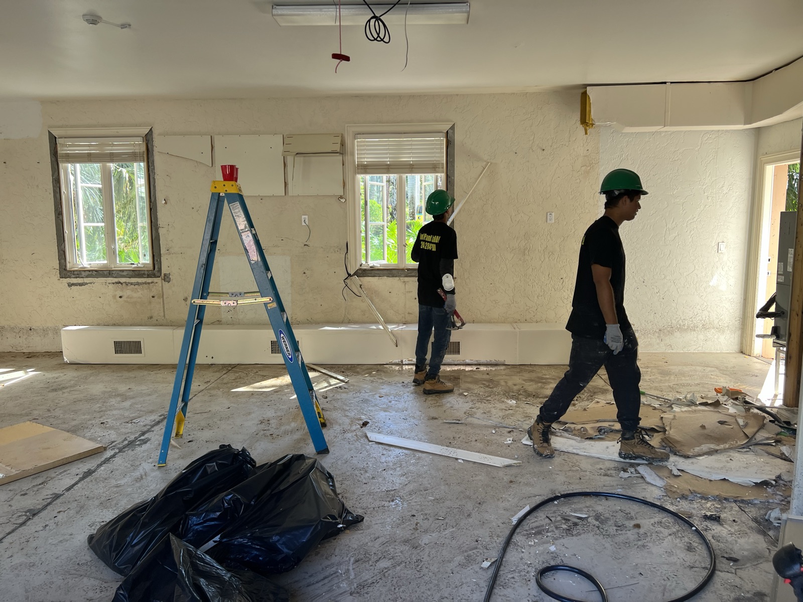 Demolition crew removing interior walls and debris